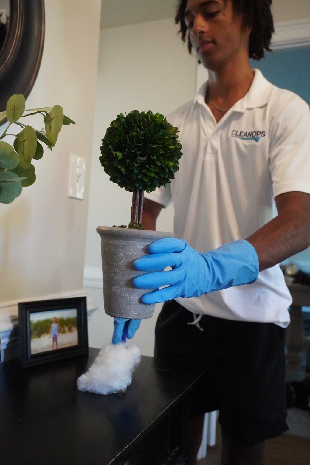 Clean Ops Solutions team member dusting decor during a house cleaning